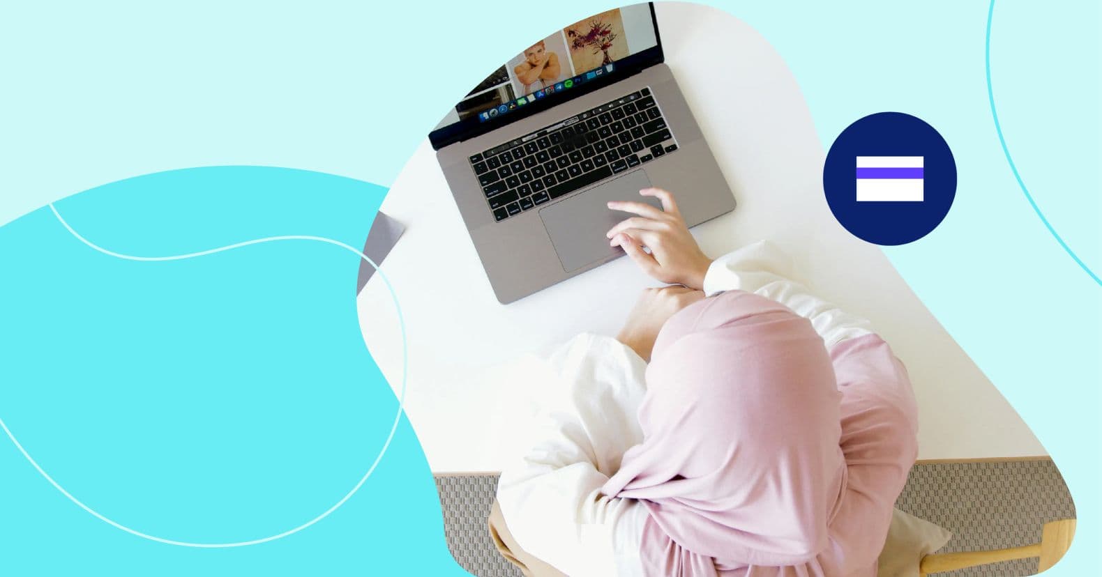 A person in a pink headscarf working on a laptop at a white desk with papers and rolls of paper tubes. How much do social media ads cost.