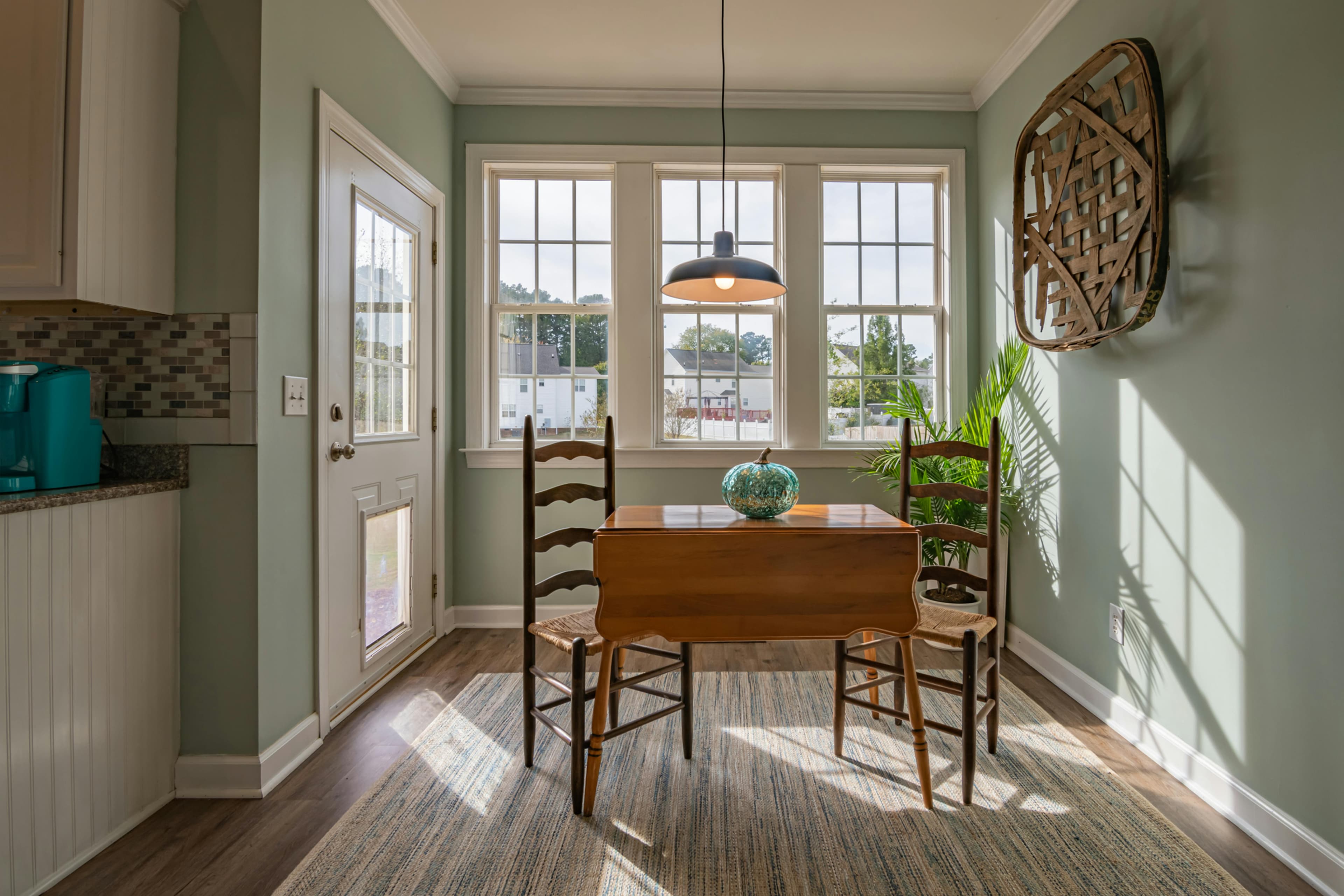 A cozy and bright dining area with natural light pouring through the windows. The table, decorated with a ceramic centerpiece, invites a warm and inviting ambiance. Keywords: affiliate landing page, home decor, interior design.