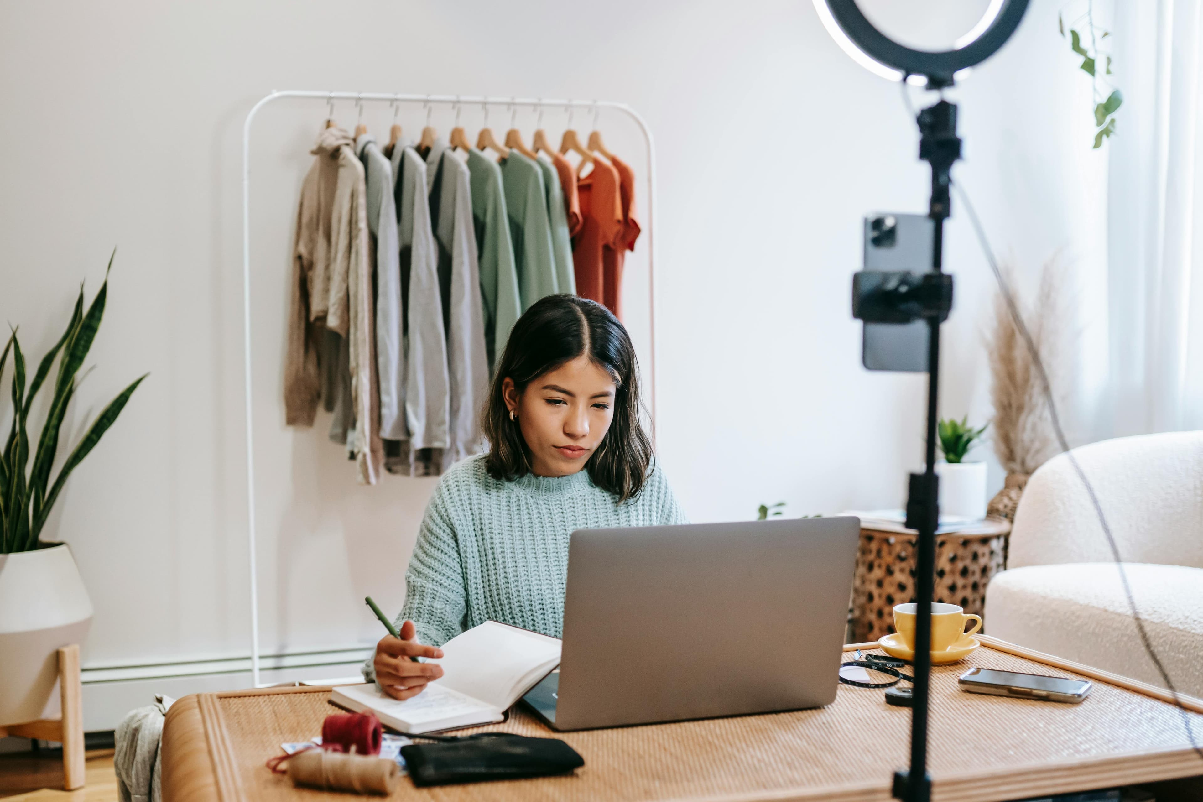 A woman working on her laptop while preparing for a recording session in a cozy home office. The image answers "what is conversion in marketing?" by demonstrating how consistent, high-quality content can encourage viewers to make decisions such as signing up for services or making purchases.