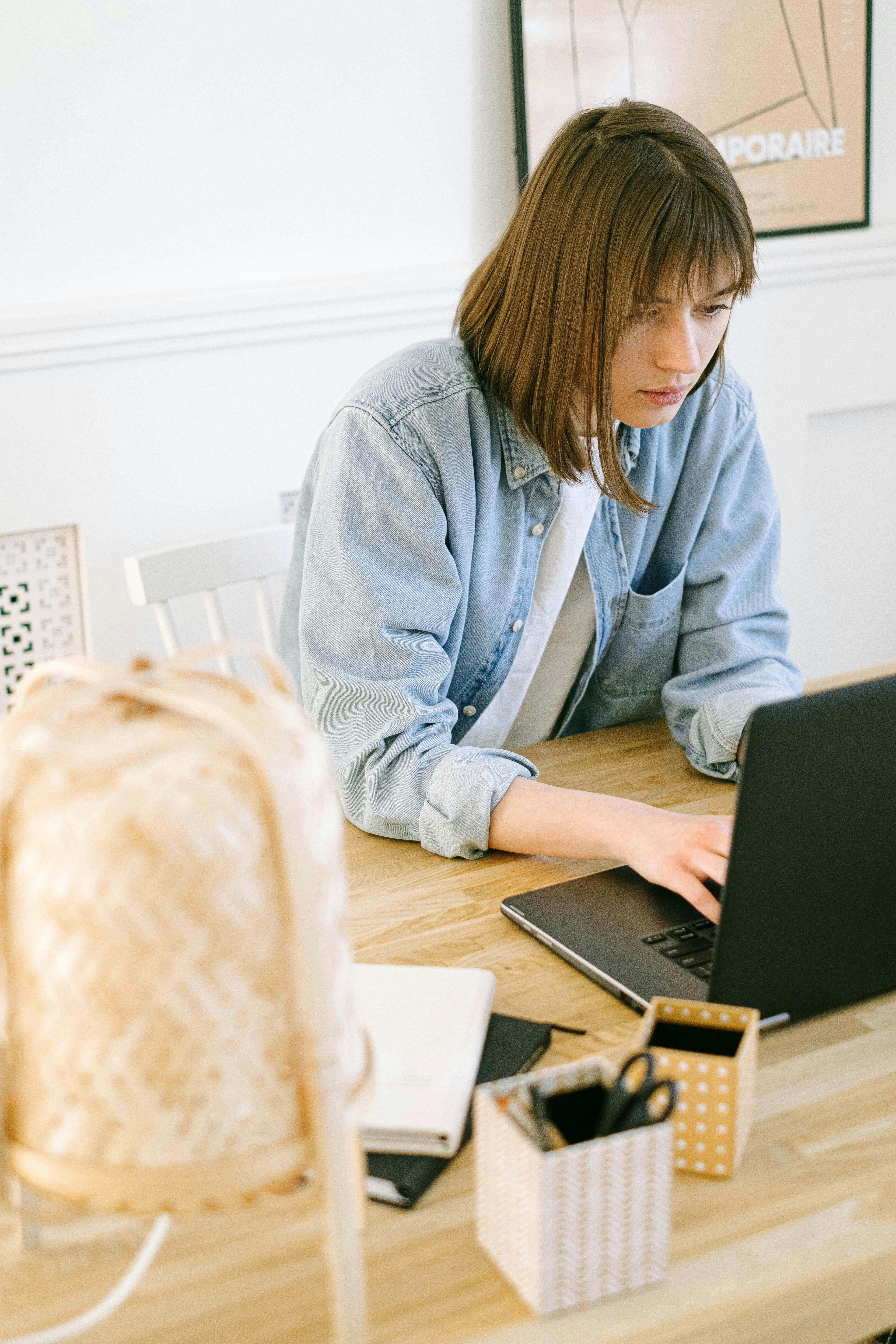 A focused individual typing on a laptop, surrounded by office supplies and an organized desk setup. Perfect representation of crafting best lead generation landing pages for business success.