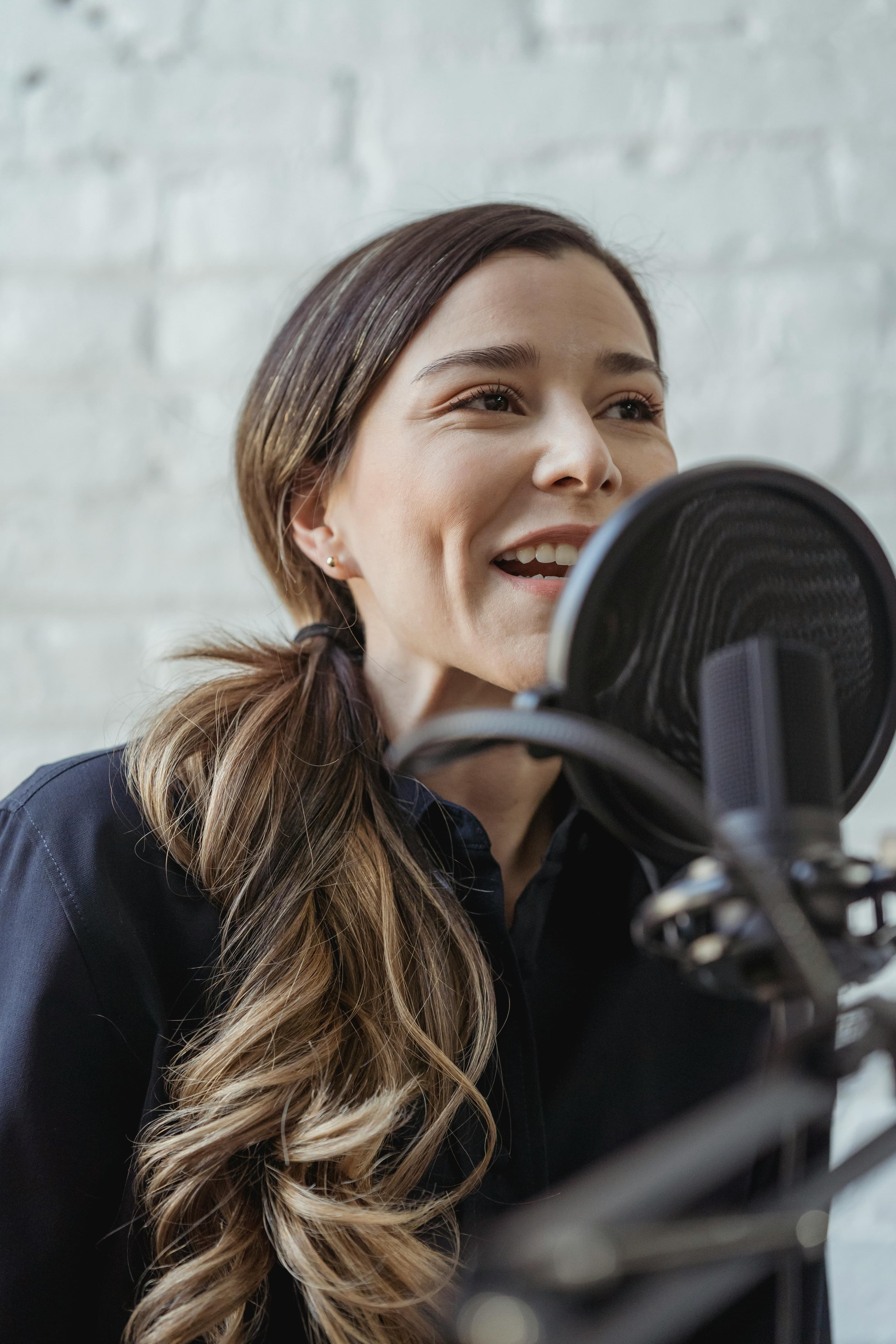 A confident woman speaking into a microphone, illustrating how the benefits of marketing automation enhance effective communication and outreach.