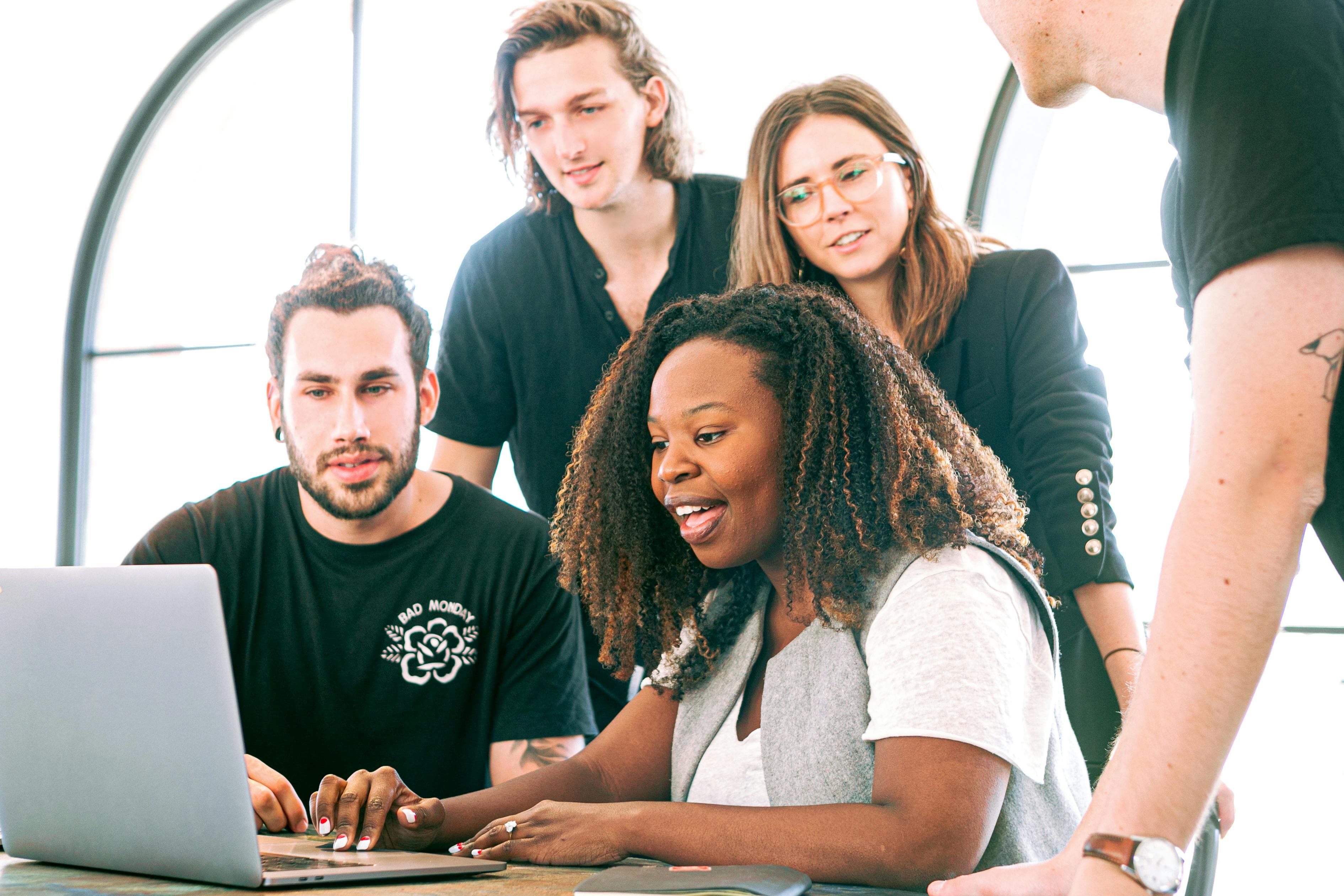  A team gathered around a laptop, actively engaging in discussion and problem-solving. This dynamic setup illustrates teamwork, communication, and collaboration as essential elements in the "7 factors of good design context."