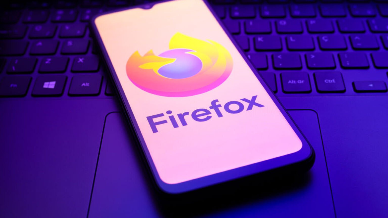 The Mozilla Firefox logo appears on the screen of a smartphone