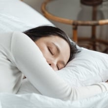 Person sleeping in white bed 