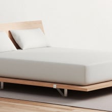 Bed with wooden frame in room