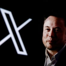 elon musk pictured with x logo behind him