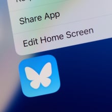 The Bluesky app logo on an iPhone home screen. 