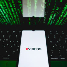 The XVideos logo is being displayed on a smartphone screen