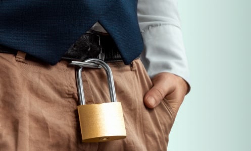 Close-up of a gold padlock hanging from a man's belt