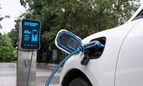 An electric car charges at a port.