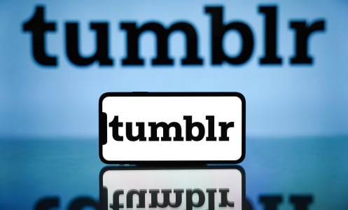 Tumblr logo displayed on a mobile phone screen and in the background.