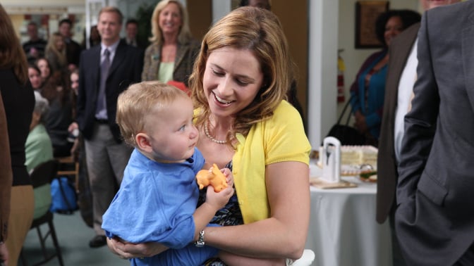 A woman holding a baby girl and smiling.