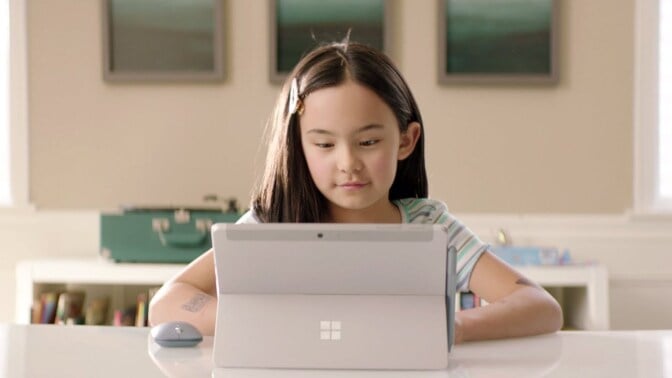 Child sitting in front of a laptop.