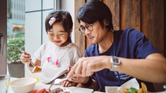 a father and daughter eating a meal