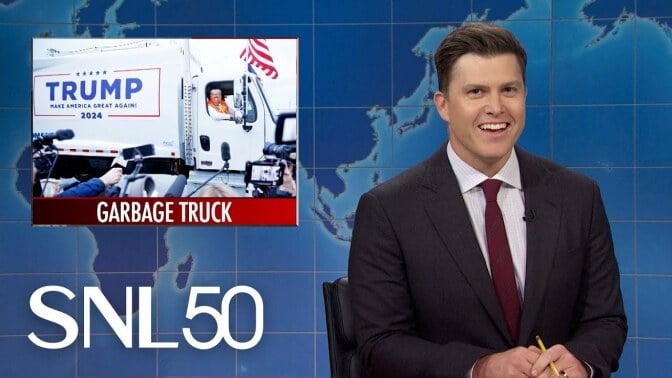 colin jost joking on SNL set with graphic about trump's gabage truck