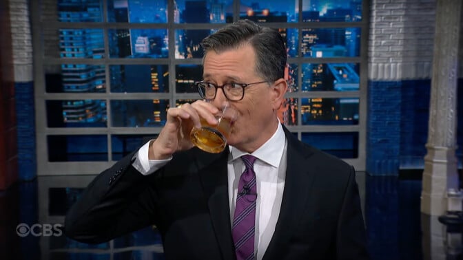 Stephen Colbert drinking bourbon on The Late Show with Stephen Colbert.