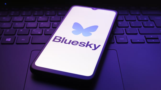 bluesky logo on phone on top of keyboard