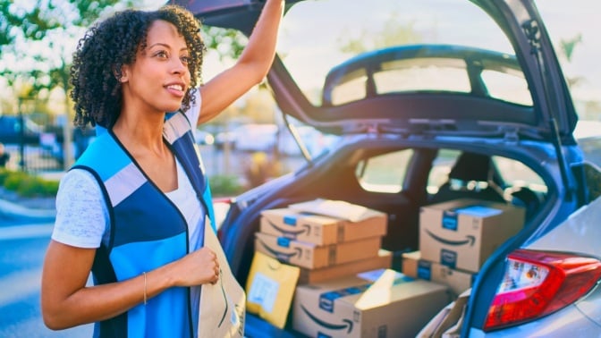 Amazon driver loading Amazon deliveries into a car