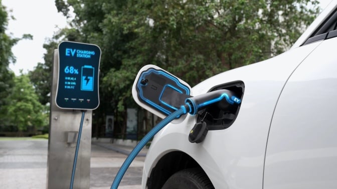 An electric car charges at a port.