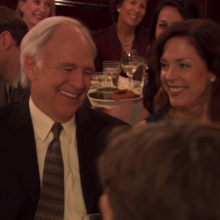 A man (Robert Pine as Gerald Halpert) and a woman (Perry Smith as Betsy Halpert) sitting at a dinner table in the "Niagara" episode of "The Office."