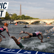 Atheletes jump in the river Seine, with Pont Neuf and the Eiffel Tower in the background. Caption reads "Olympic effort"