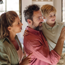 family of three looking at a smart thermostat