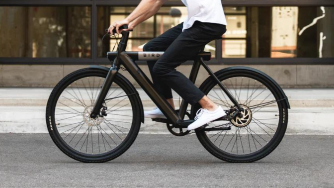 close up of waist down of man riding Bird e-bike on street 