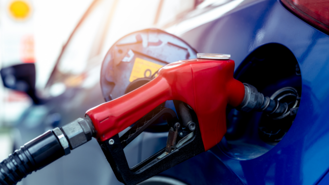 close up of a gas pump filling a blue car 