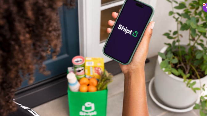 Person holding a smartphone with the Shipt logo 